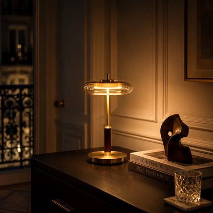 Lampe Lentis allumée le soir sur une commode, lumière ambrée diffusée sous le disque en verre fumé