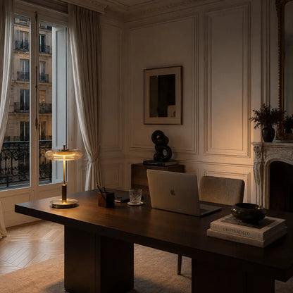 Lampe Lentis allumée dans un appartement haussmannien, parquet chevron, moulures et cheminée en marbre