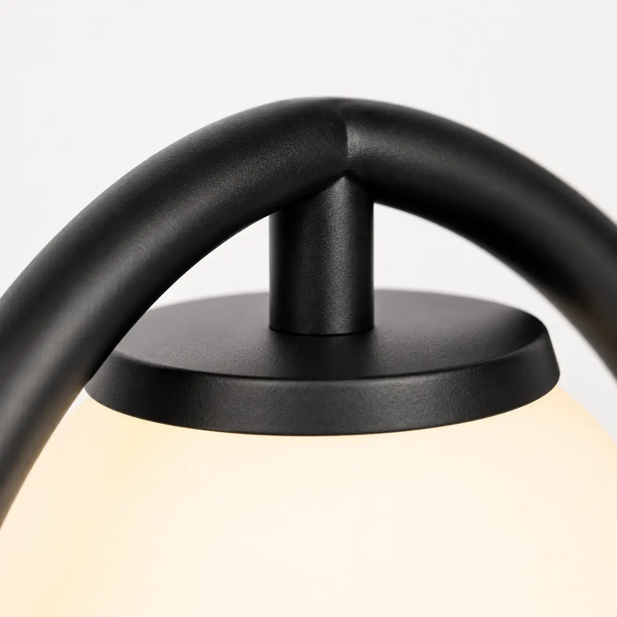 Détail de la lampe Halos : fixation entre l'anneau en métal noir mat et le globe en verre opalin