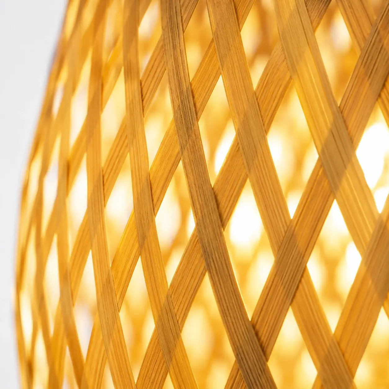 Détail de la lampe Textura : lamelles de bambou tressées en losange, rétroéclairées par la lumière chaude