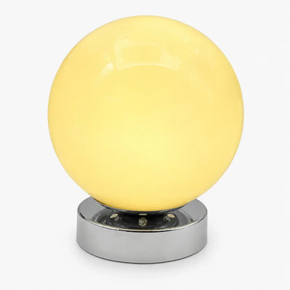 Lampe de bureau Ignis à globe en verre soufflé jaune pâle et base en métal chromé, sur fond clair
