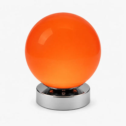 Lampe de bureau Ignis à globe en verre soufflé orange vif et base en métal chromé, sur fond clair