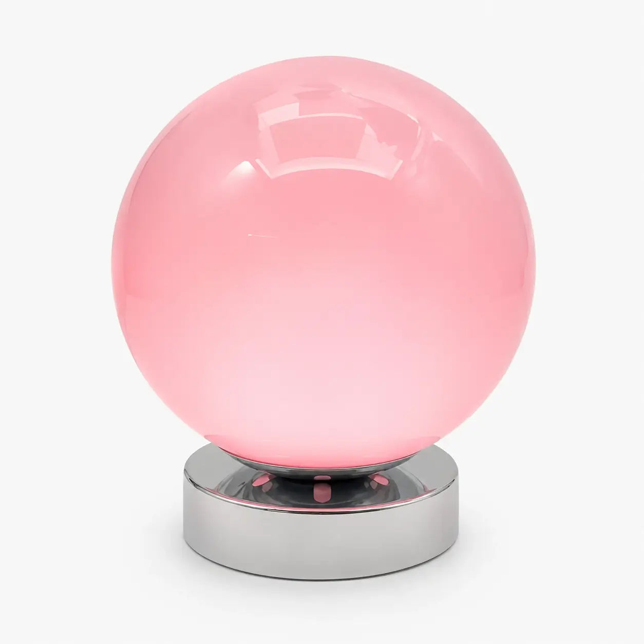 Lampe de bureau Ignis à globe en verre soufflé rose et base en métal chromé, sur fond clair