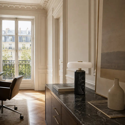 Lampe de bureau marbre Noctis posée sur un meuble dans un appartement parisien de jour