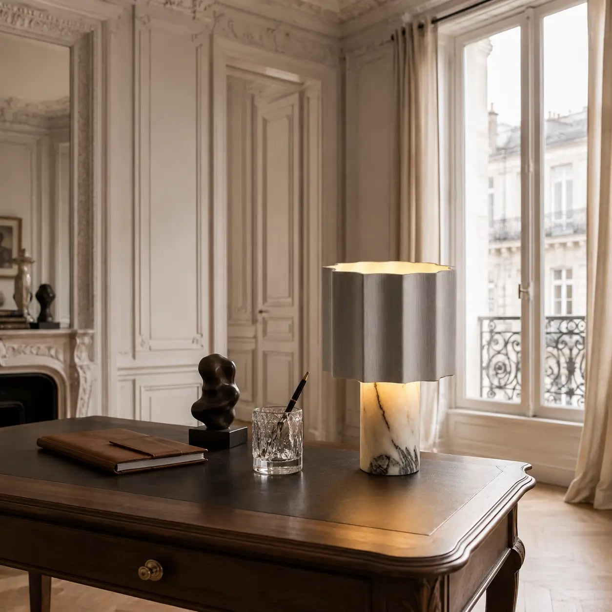 Lampe de bureau Sinus en marbre posée sur un bureau en bois près d'une fenêtre, appartement parisien