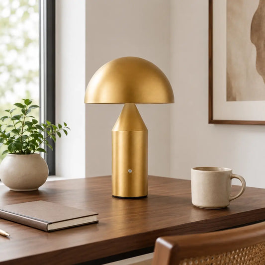 Lampe de bureau sans fil Aurata dorée posée sur un bureau bois en pleine journée