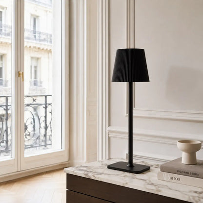 Lampe de bureau sans fil Lucerna noire posée sur une console en marbre dans un intérieur haussmannien lumineux
