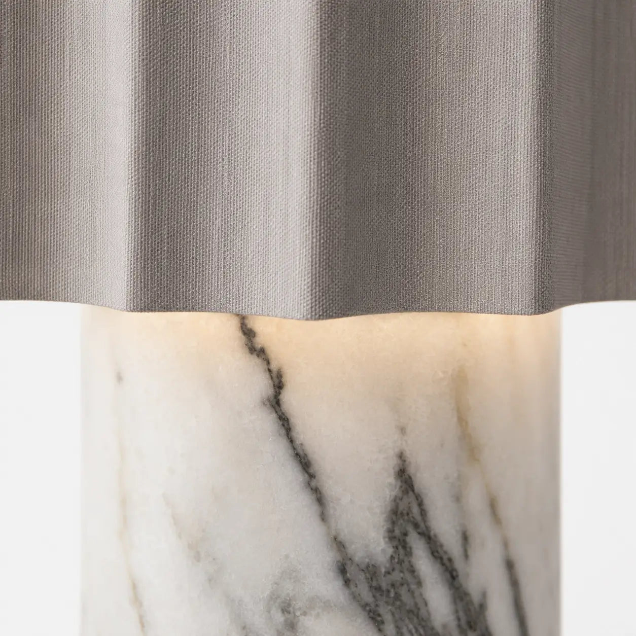 Détail de la lampe Sinus : abat-jour plissé en tissu gris et base cylindrique en marbre blanc veiné de gris