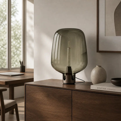 Lampe de bureau verre Nebula posée sur un meuble en bois dans un intérieur design