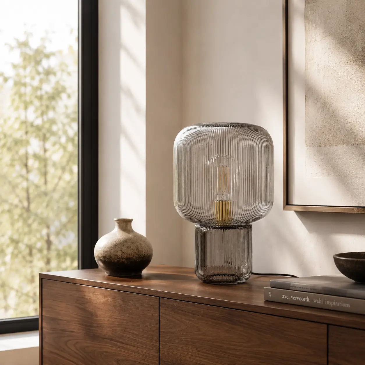 Lampe de bureau verre Stria posée sur un meuble bois dans un intérieur lumineux