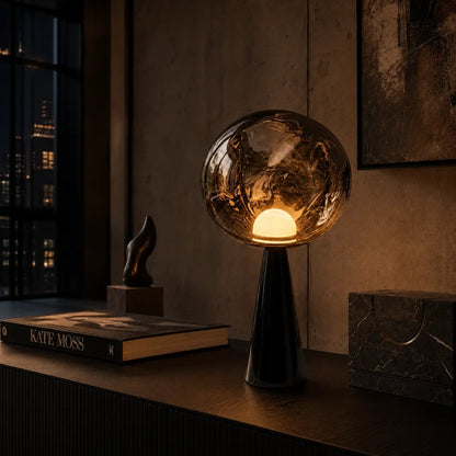 Lampe Umbra allumée le soir, lueur chaude diffusée à travers le globe en verre fumé